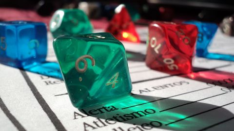 Colorful polyhedral dice resting on a character sheet during a tabletop role-playing game session